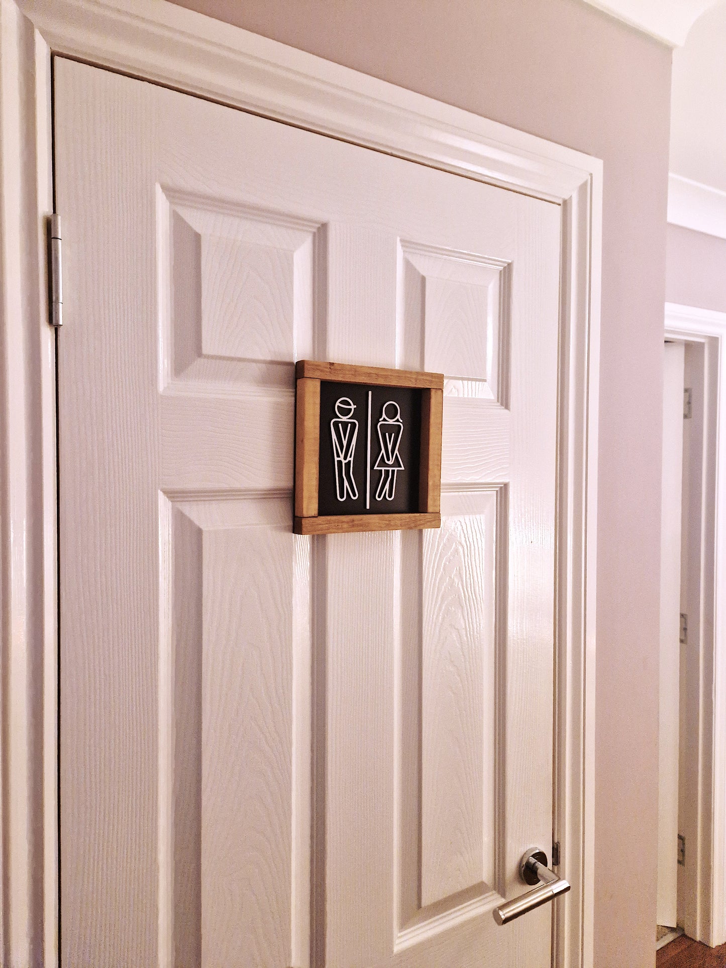 Wooden toilet sign with stick figures