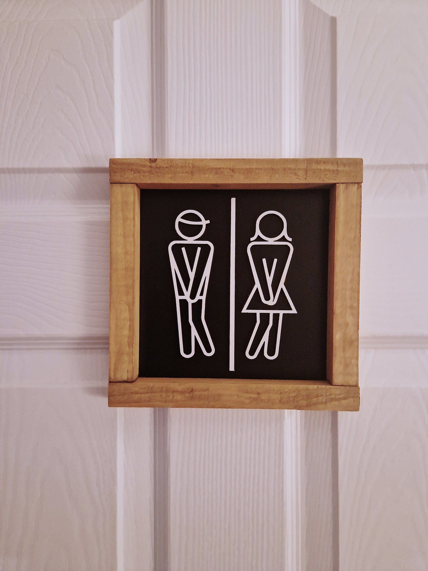 Wooden toilet sign with stick figures