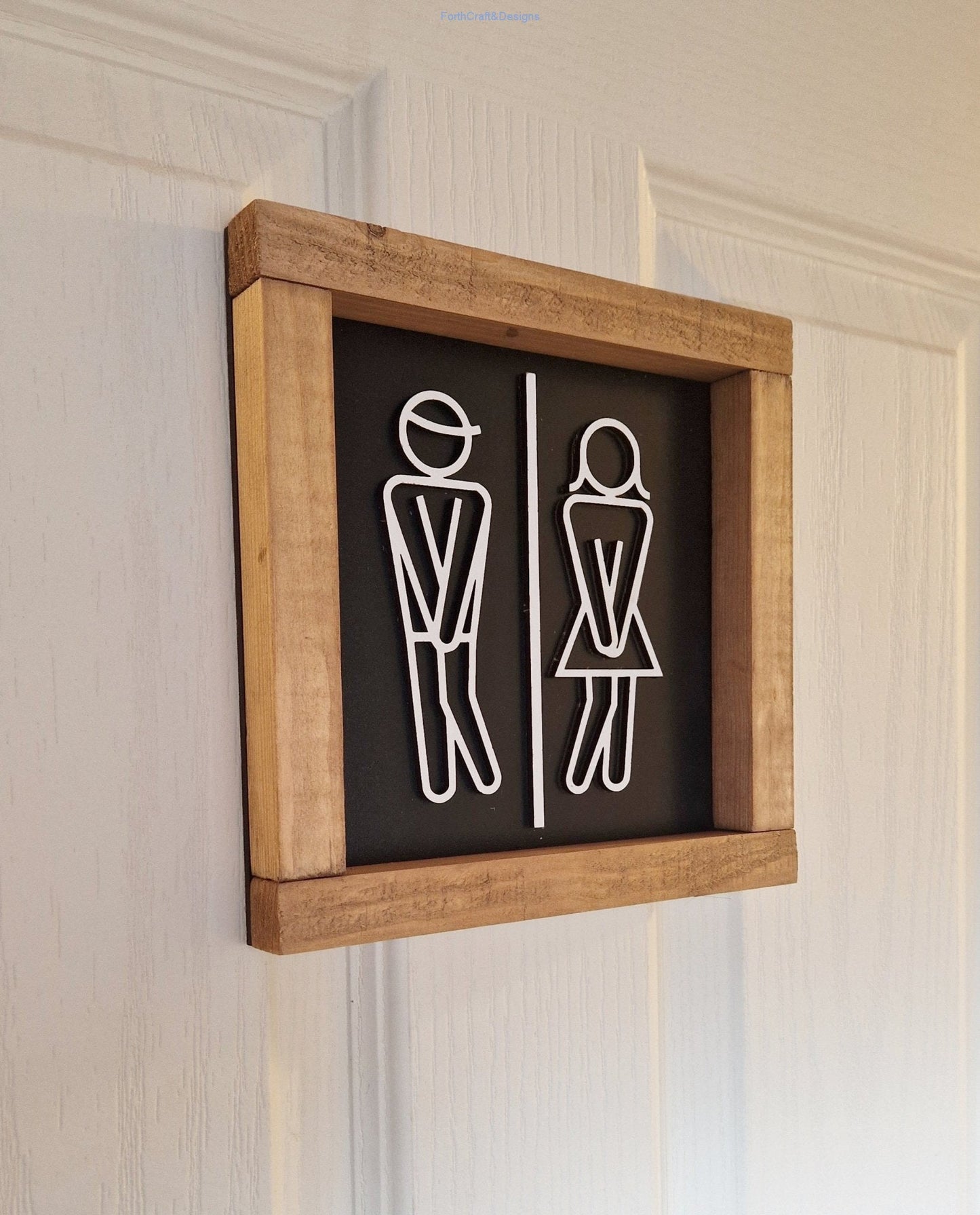 Wooden toilet sign with stick figures