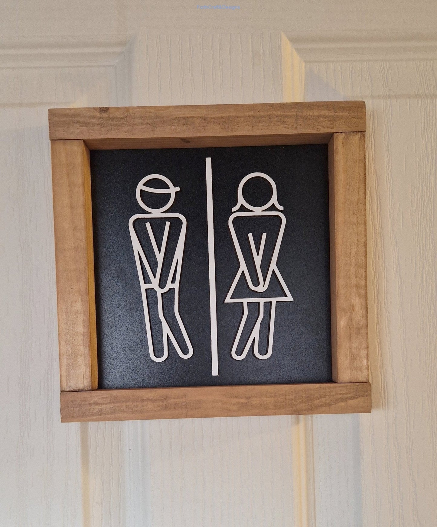Wooden toilet sign with stick figures