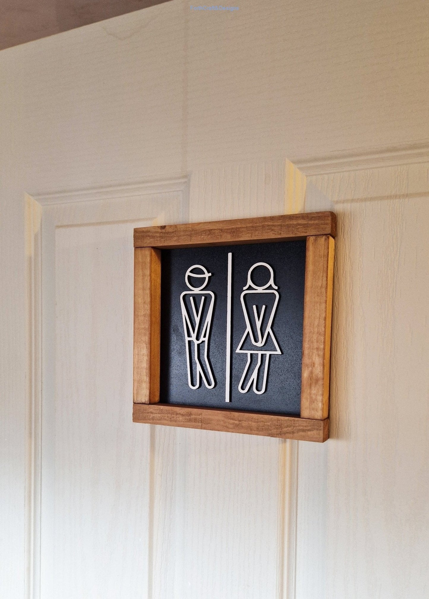 Wooden toilet sign with stick figures