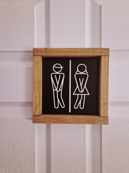 Wooden toilet sign with stick figures